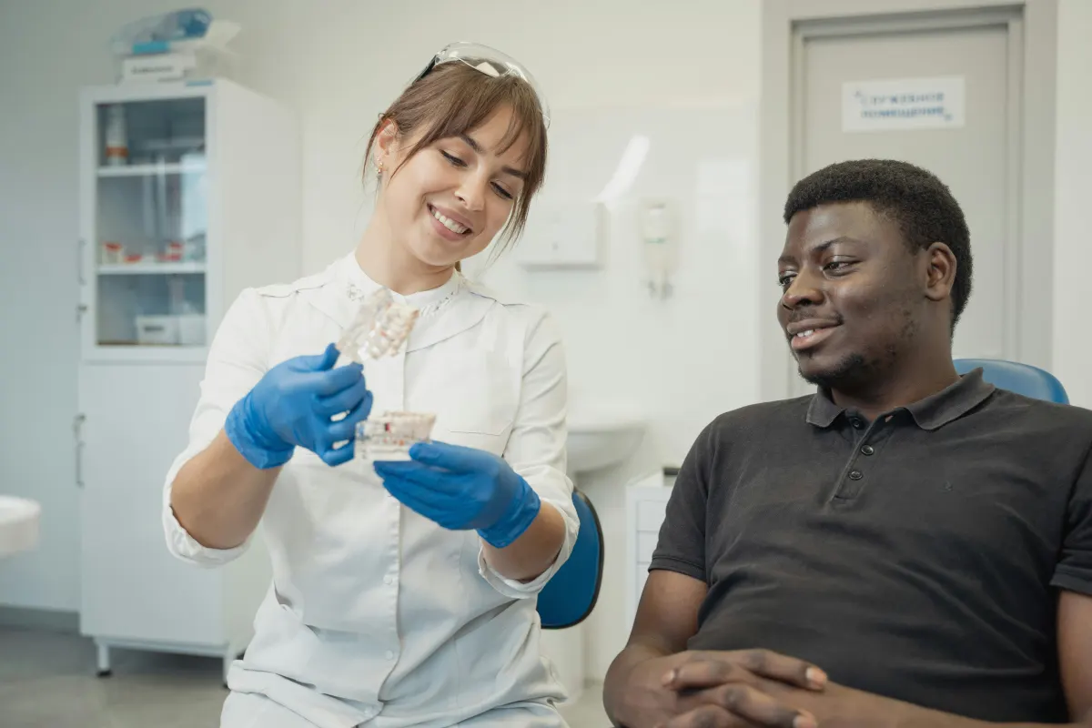 Dentist explaining clear aligner options with a dental model